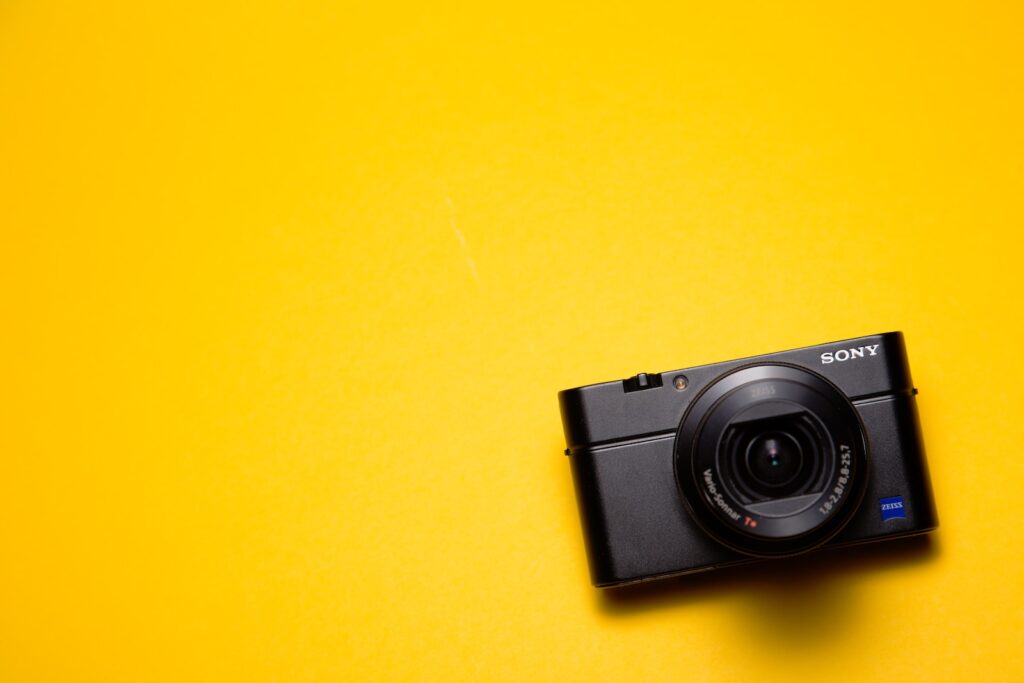 black Sony point-and-shoot camera on yellow surface
