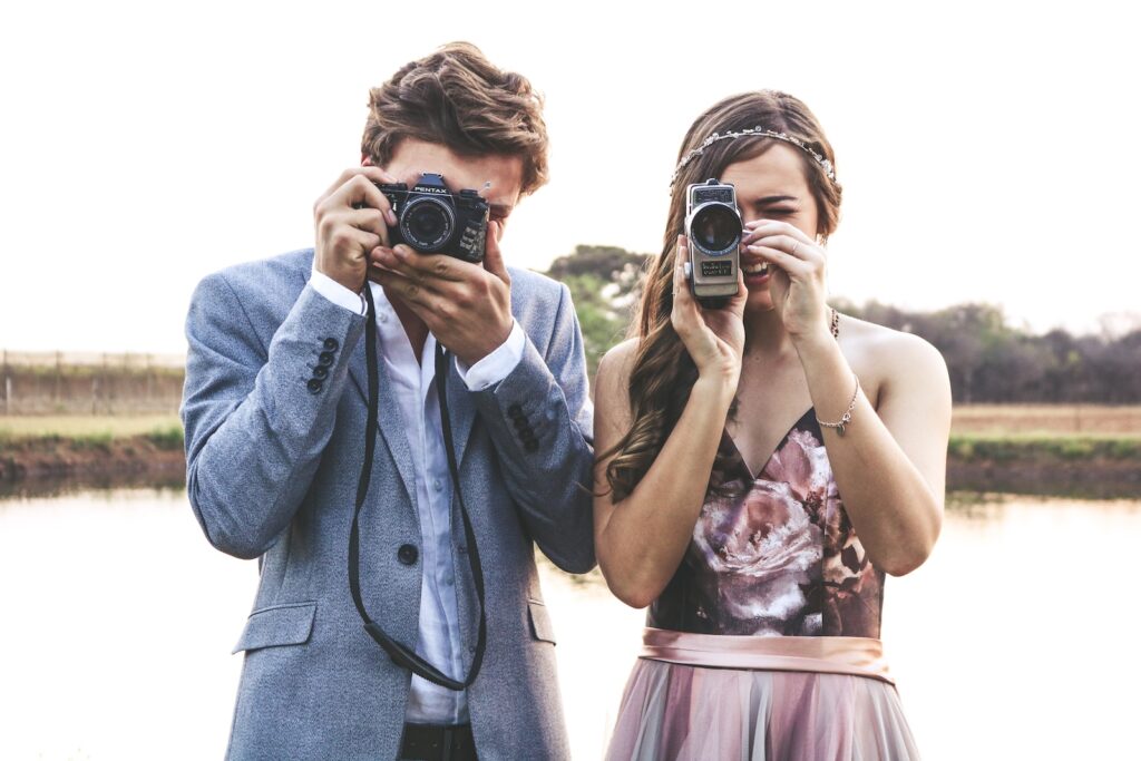 woman and man holding cameras