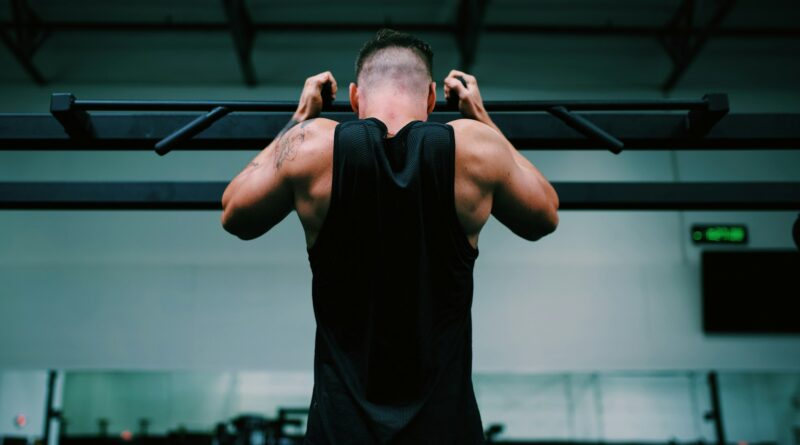 man in black tank top raising his hands