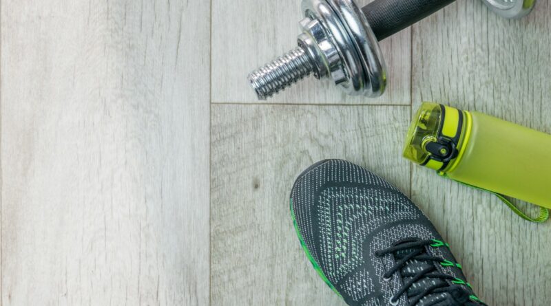 a pair of shoes and a water bottle on a wooden floor